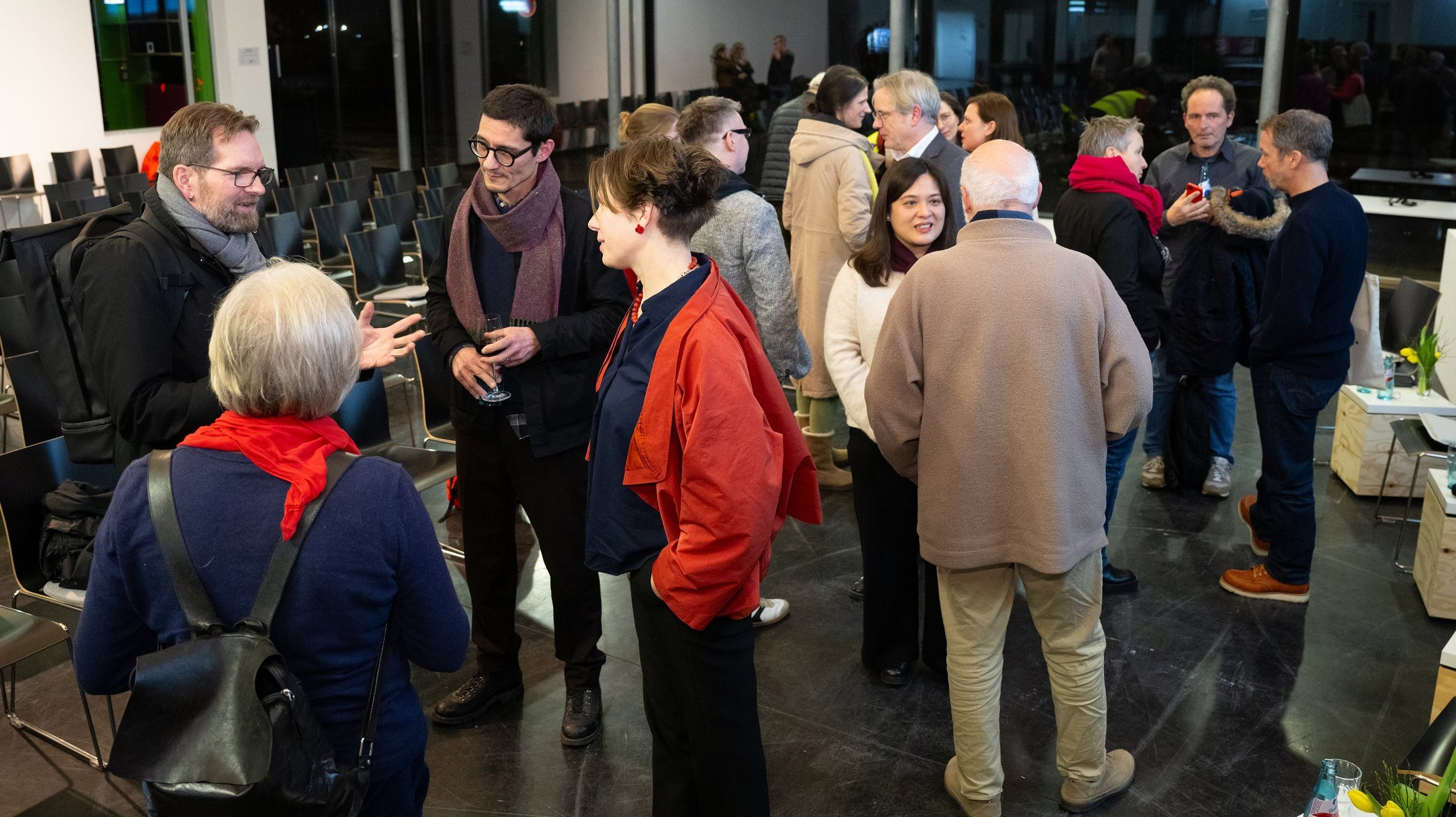 Panelisten und Gäste stehen beim lockeren Austausch zusammen