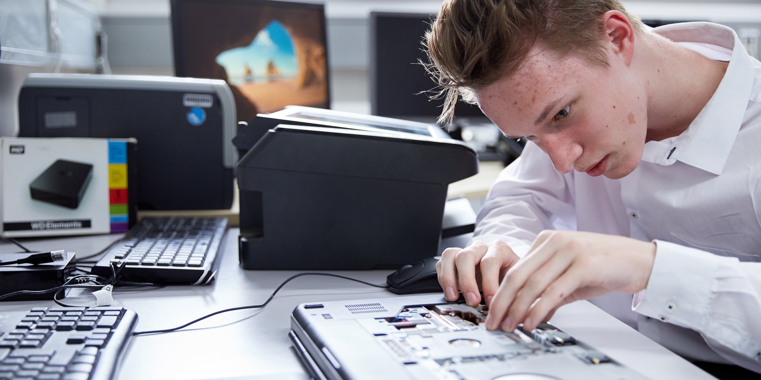 Auszubildender arbeitet am Inneren eines Laptops