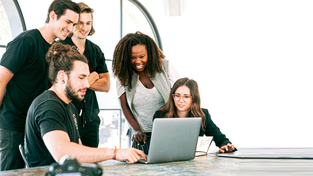 A group of cheerful people planning on their laptops