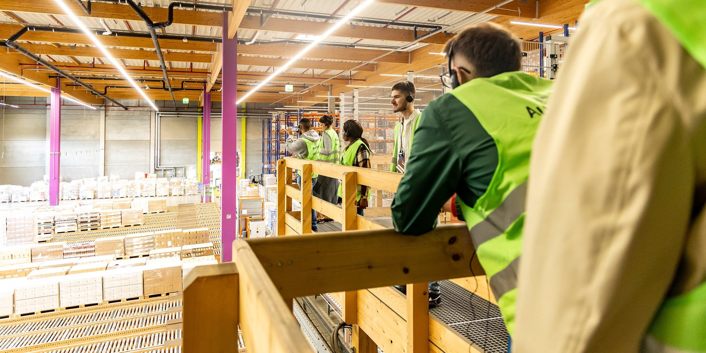 Personen mit Warnwesten in einer Lagerhalle