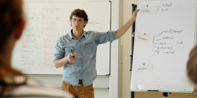 Ein Trainer steht vor einer Flipchart und erklärt etwas.